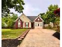 Charming single-Gathering home showcasing a well-maintained front yard, a brick facade, and a private driveway at 10408 Milstead Ct, Charlotte, NC 28215