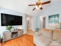 Comfortable living room with wood floors, a ceiling fan, and a decorative entertainment center at 10408 Milstead Ct, Charlotte, NC 28215