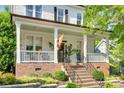 Inviting front porch with rocking chairs, complemented by brick accents and lush landscaping at 117 Mills Ln, Fort Mill, SC 29708