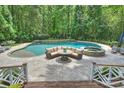 Stunning pool area with a waterfall feature, integrated spa, and comfortable outdoor seating at 12028 Royal Lytham Ct, Charlotte, NC 28277