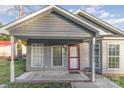 Charming single-story home with gray siding and a covered front porch and red door at 1263 Crawford Rd, Rock Hill, SC 29730