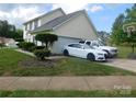 View of home with driveway and manicured landscaping at 12803 Matisse Ln, Charlotte, NC 28215