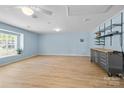 Spacious basement with light blue walls, laminate flooring, and ample natural light from large windows at 13914 Loch Loyal Dr, Charlotte, NC 28273