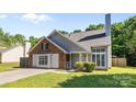Quaint one story home featuring manicured lawn, brick and gray siding, and mature trees in a desirable neighborhood at 13914 Loch Loyal Dr, Charlotte, NC 28273