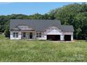 New construction home showcasing a two-car garage and lush, green surroundings at 1479 Mocksville Hwy # 23, Statesville, NC 28625