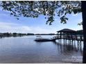 Beautiful waterfront home featuring a private boat dock, with clear blue waters and open sky at 17112 Green Dolphin Ln, Cornelius, NC 28031