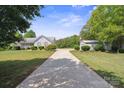 Charming single-story home with a lush lawn, complemented by a detached two-car garage and a long driveway at 260 Treebark Rd, Statesville, NC 28625