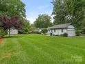 Expansive backyard with lush green lawn, mature trees, and detached garage at 3615 Champaign St, Charlotte, NC 28210