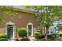 Brick townhouse with green front door, white trim and manicured bushes at 3736 Melrose Cottage Dr, Matthews, NC 28105