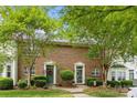 A well-kept brick townhouse with dual entryways and mature landscaping providing curb appeal at 3736 Melrose Cottage Dr, Matthews, NC 28105