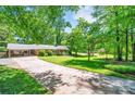 Brick ranch home featuring a spacious driveway, mature landscaping and a covered carport at 3810 Springway Dr, Gastonia, NC 28056