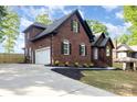 Brick home featuring a side-entry garage, lush landscaping, and a classic architectural design at 4907 Ardenwoods Dr, Charlotte, NC 28215