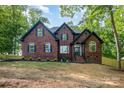 Stately brick home featuring a well-manicured lawn, mature trees and traditional architectural details at 4907 Ardenwoods Dr, Charlotte, NC 28215