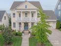 Inviting two-story home featuring a classic front porch and well-manicured lawn at 5250 Meadowcroft Way, Fort Mill, SC 29708