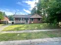 Charming single-story brick home featuring a cozy front porch and well-maintained lawn at 601 Scottsbrook Dr, Charlotte, NC 28213