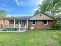 Charming single-story brick home featuring a cozy front porch and well-maintained lawn at 601 Scottsbrook Dr, Charlotte, NC 28213