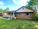 Charming single-story brick home featuring a cozy front porch and well-maintained lawn at 601 Scottsbrook Dr, Charlotte, NC 28213