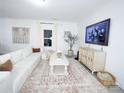 Bright living room features a plush white sofa, stylish rug, and contemporary decor at 6114 Paw Village Rd, Charlotte, NC 28214