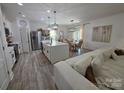 Bright living area with island, stainless steel refrigerator and a view of the dining area at 6114 Paw Village Rd, Charlotte, NC 28214