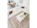 Open living room design with white sofa, area rug and decorative pillows at 6114 Paw Village Rd, Charlotte, NC 28214