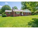Lovely brick home on a lush lawn, featuring dark shutters and mature trees at 712 2Nd Nw Ave, Conover, NC 28613
