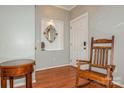 Cozy foyer with hardwood floors, a decorative mirror niche, and a comfortable rocking chair at 7128 Rock Bass Ct, Concord, NC 28025
