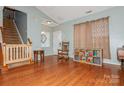 Open living room featuring hardwood floors, a staircase, and a cozy seating area at 7128 Rock Bass Ct, Concord, NC 28025