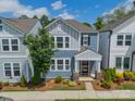 Charming two-story home with blue siding, white trim, and landscaped front yard with colorful flowers at 804 Lyndon Station Dr, Pineville, NC 28134