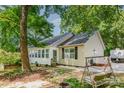 Inviting exterior with a cozy porch and swing, nestled in a serene, tree-filled yard at 814 Independence Dr, Wingate, NC 28174