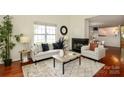 A bright living room that connects to dining area with a fireplace at 8233 Christmas Ct, Charlotte, NC 28216