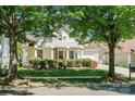 Inviting two-story home framed by mature trees and lush landscaping, with a well-manicured lawn at 1027 Feather Oak Ln, Matthews, NC 28104