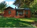 Charming brick home featuring a cozy front porch and well-maintained lawn at 1101 Spruce St, Charlotte, NC 28203
