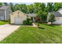 Charming single-story home with an attached garage, lush lawn, and mature landscaping at 11224 Amber Glen Dr, Charlotte, NC 28269