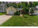 Charming single-story home with an attached garage, lush lawn, and mature landscaping at sunset at 11224 Amber Glen Dr, Charlotte, NC 28269