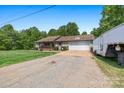 Ranch style home with a spacious driveway and attached two car garage and large front yard at 130 Helen Dr, Statesville, NC 28625