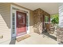 Inviting front porch with stone columns and cozy rocking chairs by a wood and glass front door at 13502 Brandon Trail Dr, Charlotte, NC 28213