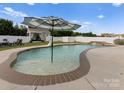 Backyard oasis featuring a beautiful in-ground pool with an umbrella and an outdoor cabana at 137 Sugar Magnolia Dr, Mooresville, NC 28115