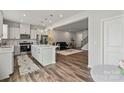 Open-concept kitchen with a large island, stainless steel appliances, and seamless flow into the living area at 15622 Little Bluestem St, Charlotte, NC 28278