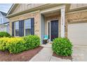 Inviting front porch with a bench, lush greenery, and brick accents enhancing curb appeal at 16012 Tulloch Rd, Charlotte, NC 28278