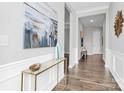 Elegant hallway featuring hardwood floors, decorative console table, and neutral wall colors at 16012 Tulloch Rd, Charlotte, NC 28278