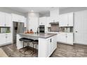 Modern kitchen with white cabinetry, stainless steel appliances, and a spacious center island at 16012 Tulloch Rd, Charlotte, NC 28278