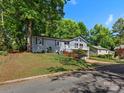 Charming gray two-story home nestled among mature trees with an inviting front porch at 16049 Pago Pago Dr, Fort Mill, SC 29708