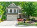 Two-story home with lush landscaping, attached garage, and inviting front porch at 16507 Palisades Commons Dr, Charlotte, NC 28278