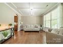 Inviting living room with hardwood floors, tray ceiling, decorative lighting, and large windows, offering a comfortable living space at 16507 Palisades Commons Dr, Charlotte, NC 28278