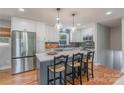 Bright kitchen with white cabinets, stainless steel appliances, and seating at the gray island at 2009 Edgewater Dr, Charlotte, NC 28210