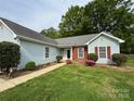 Inviting exterior view showcasing manicured lawn, walkway, and charming details of this beautiful single story home at 2504 Faircroft Way, Monroe, NC 28110