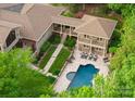 An aerial view of the home featuring a pool, patio, lush landscaping, and manicured lawn at 2915 Cutter Ct, Waxhaw, NC 28173