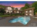 Beautiful backyard pool with a stone surround, lounge chairs and a covered patio at 2915 Cutter Ct, Waxhaw, NC 28173