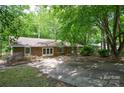 A brick house with a large driveway, and trees in the front yard at 316 Anne Ave, Waxhaw, NC 28173