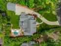 Aerial view showcases this landscaped property with pool, patio, detached garage, circular driveway, and mature trees at 331 Anthony Cir, Charlotte, NC 28211